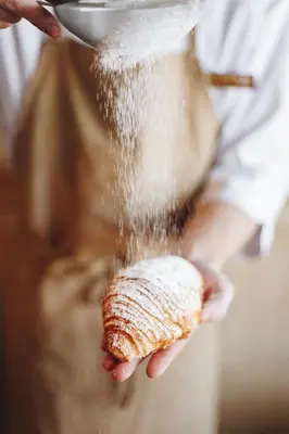 a person pouring food into a pot with a whisk at Feel good Resort Johannis in Tirolo
