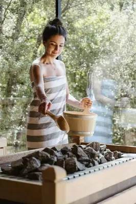 a woman standing in front of a stove preparing food at Feel good Resort Johannis in Tirolo
