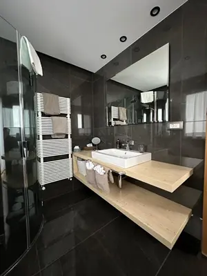 two beds in a room with a mirror at Garnì Villa Erna in Selva di Val Gardena