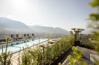 a view of a swimming pool with mountains in the background at Landsitz Stroblhof in Tirolo