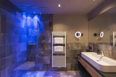 a bathroom with a shower and a sink and a tub at Landsitz Stroblhof in Tirolo