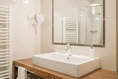 a white bathroom with a sink and a mirror at Landsitz Stroblhof in Tirolo