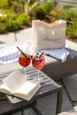 two wine glasses and a book on a table at Landsitz Stroblhof in Tirolo