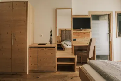 a bedroom with a desk and a bedroom with a bed at Pension Moarhof in Feldthurns