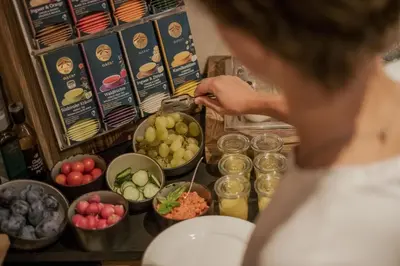a woman standing in front of a buffet of food at Pension Moarhof in Feldthurns