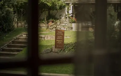 a view from a window of a garden with a sign at Pension Moarhof in Feldthurns