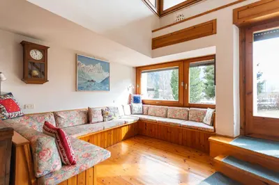 a living room with a couch and a window at Villa Margherita in Moena