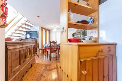 a kitchen with wooden cabinets and a dining room at Villa Margherita in Moena