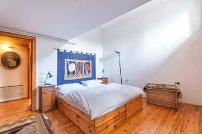 a bedroom with a large bed and a wooden floor at Villa Margherita in Moena