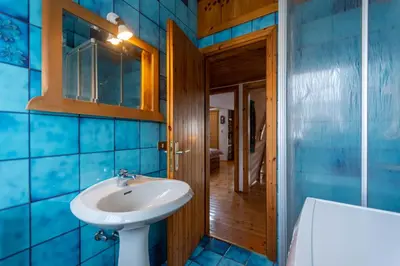 a bathroom with blue tiled walls and a sink at Villa Margherita in Moena