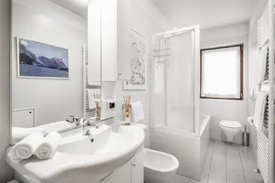 a white bathroom with a sink and a toilet at Residence As'Odei in San Cassiano