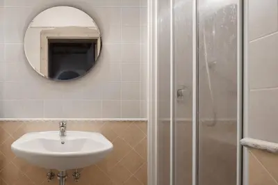 a bathroom with a sink and a shower with a mirror at Residence As'Odei in San Cassiano