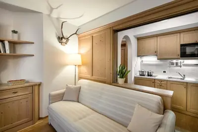a living room with a couch and a kitchen at Residence As'Odei in San Cassiano
