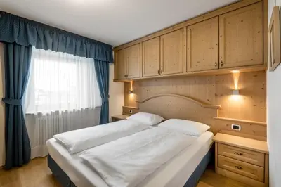 a bedroom with a large bed and a window at Residence As'Odei in San Cassiano