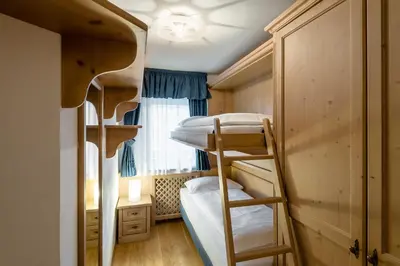 a room with two bunk beds and a window at Residence As'Odei in San Cassiano