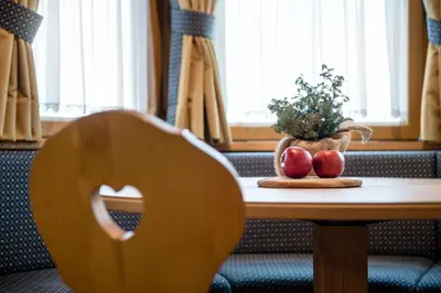 a table with two apples and a vase of flowers on it at Residence As'Odei in San Cassiano