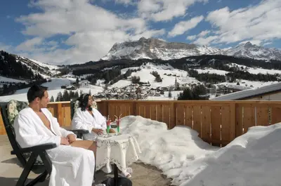 two people sitting at a table in the snow at Hotel Serena in Badia