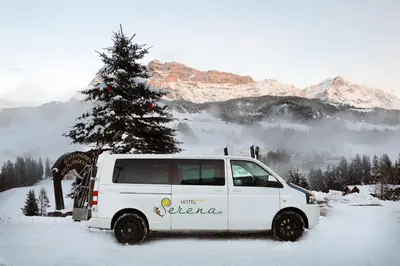 a white van parked in the snow with a christmas tree at Hotel Serena in Badia
