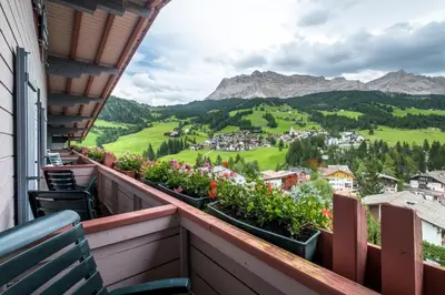 a balcony with a view of a town and mountains at Hotel Serena in Badia