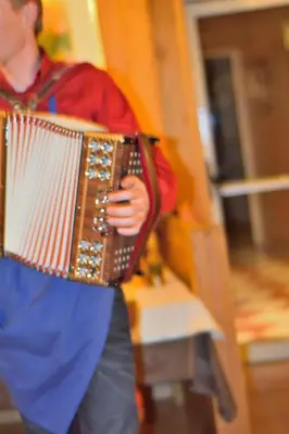a man playing an accordion on a staircase at Hotel Serena in Badia
