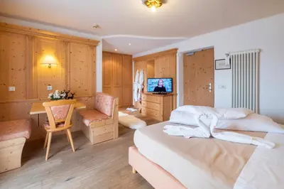 a bedroom with a bed and a desk and a television at Hotel Serena in Badia