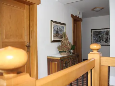 a hallway with a wooden door and a stairway at Residence Rottonara in Corvara in Badia