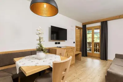 a living room with a table and a couch at Residence Rottonara in Corvara in Badia