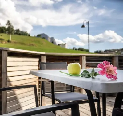 a white table and chairs on a deck at Martina Breakfast Lodge in Castelrotto
