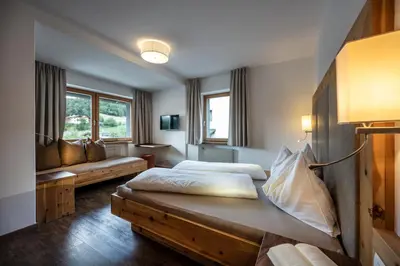 a hotel room with two beds and a couch at Martina Breakfast Lodge in Castelrotto