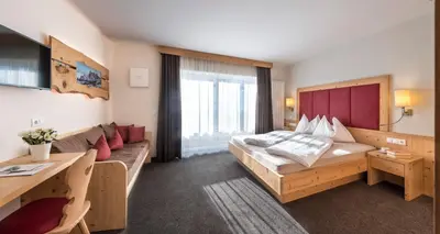 a hotel room with a bed and a couch at Martina Breakfast Lodge in Castelrotto