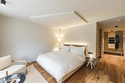 a bedroom with a large white bed and a couch at Sensoria Dolomites in Siusi