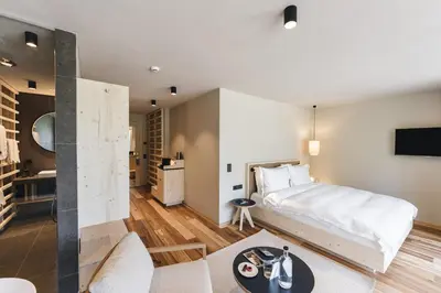 a bedroom with a bed and a living room at Sensoria Dolomites in Siusi