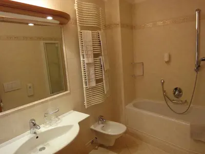 a bathroom with a sink and a toilet and a tub at Hotel zum Wolf in Castelrotto
