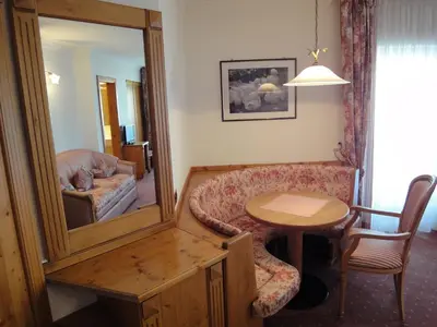 a living room with a table and a mirror at Hotel zum Wolf in Castelrotto