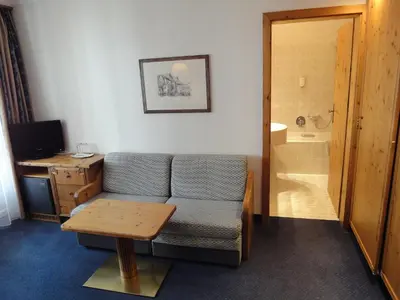 a living room with a couch and a table at Hotel zum Wolf in Castelrotto