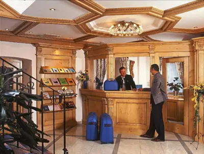 a man standing at a counter in a barber shop at Hotel zum Wolf in Castelrotto