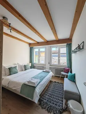 a bedroom with a large bed and a chair at City Apartment 221 in Merano