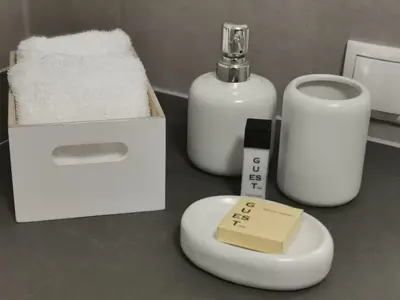 a counter with a soap and a soap dispenser and towels at City Apartment 221 in Merano