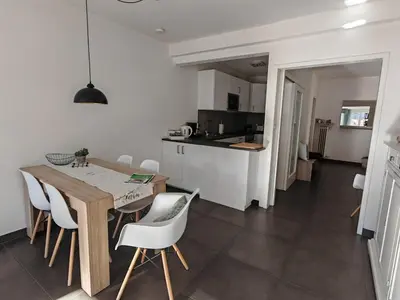 a kitchen and dining room with a wooden table and chairs at City Apartment 221 in Merano