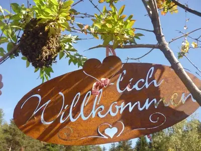 a sign hanging from a tree with the words lick wilderness at APIPURA hotel rinner in Soprabolzano