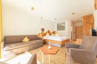 a living room with a couch and a bed at APIPURA hotel rinner in Soprabolzano
