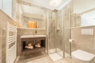 a bathroom with a shower and a sink and a toilet at APIPURA hotel rinner in Soprabolzano