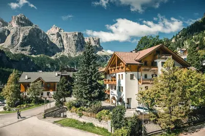 a building with snow covered trees in front of it at Pension Merisana in Colfosco