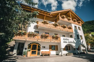 a building with a sign on the side of it at Pension Merisana in Colfosco