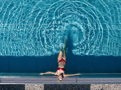 a person laying in a swimming pool at Hotel Alpenroyal in Castelrotto