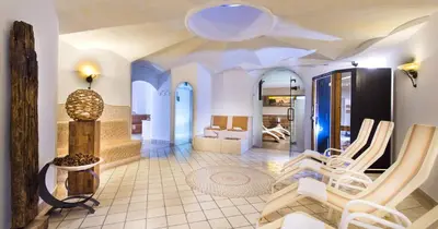 a living room with a lobby with chairs and a table at Hotel Alpenroyal in Castelrotto
