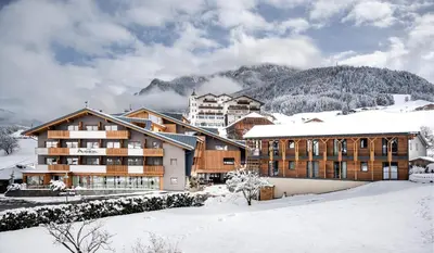 an aerial view of a building with cars parked in a parking lot at Hotel Alpenroyal in Castelrotto