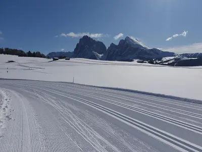 a snow covered road with mountains in the background at Hotel Alpenroyal in Castelrotto