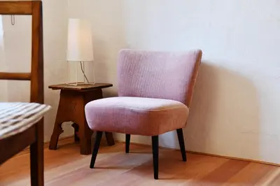 a chair sitting next to a table with a lamp at Casa Piganò in Appiano sulla Strada del Vino