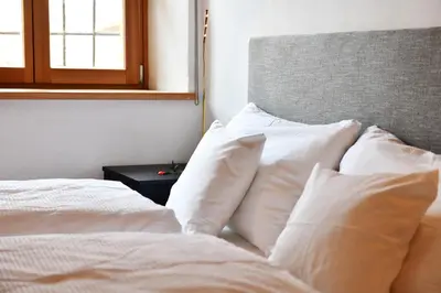 a white bed with white pillows and a window at Casa Piganò in Appiano sulla Strada del Vino